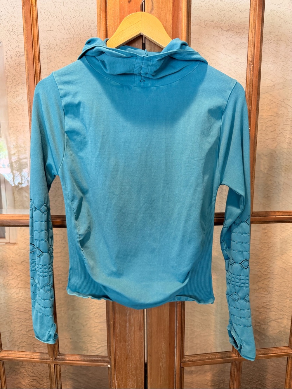 Free People Movement Teal Hooded Long-Sleeve Top with cut outs along sleeves